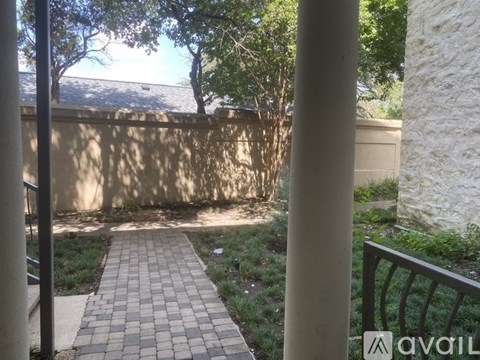 A patio with a brick walkway and a metal railing.