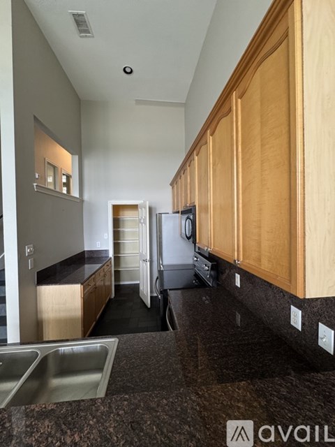 A kitchen with wooden cabinets and a granite countertop.