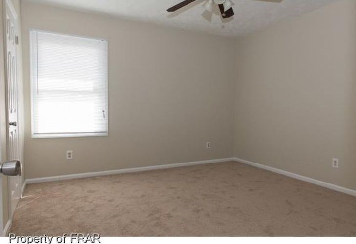 A room with a window and a ceiling fan.