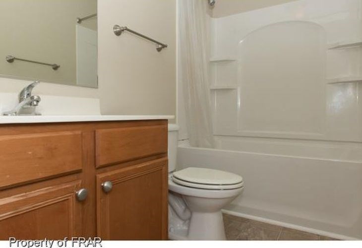 A white toilet sits next to a bathtub in a bathroom.