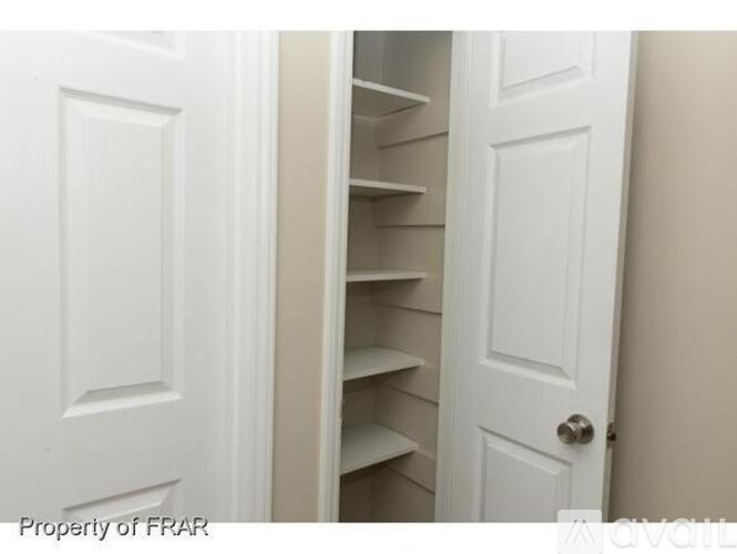 A white door is open to a white shelving unit.