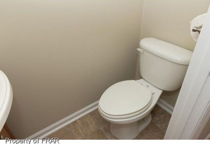 A white toilet in a small bathroom.