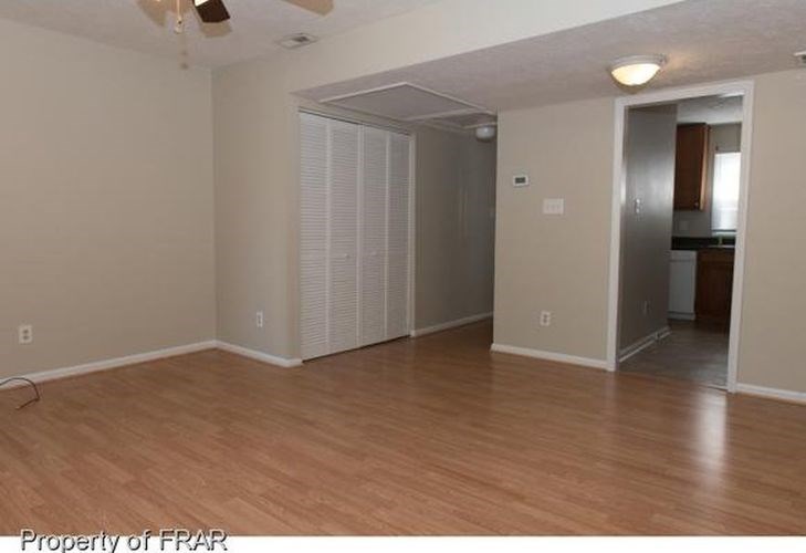 A room with wood flooring and a ceiling fan.