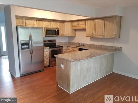 A kitchen with wooden cabinets and a granite countertop.