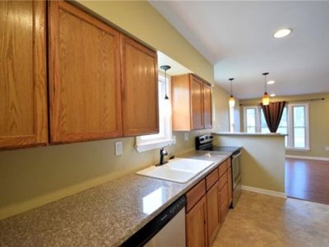 A kitchen with wooden cabinets and a granite countertop.