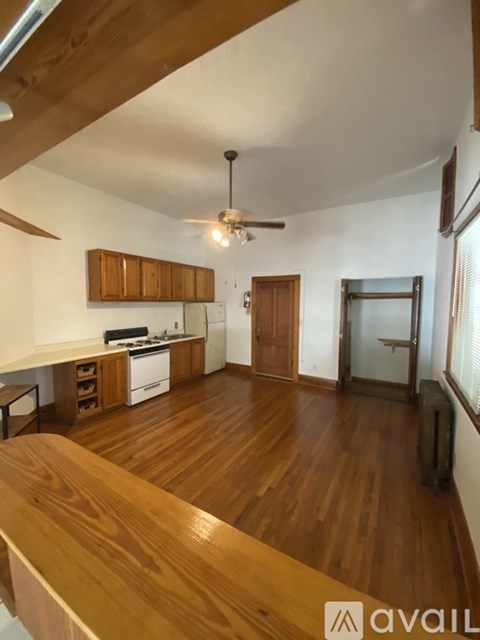 A wooden table is in the middle of a kitchen and living room.