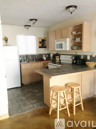 A kitchen with wooden cabinets and a white fridge.
