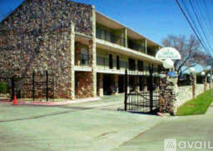 A building with a stone facade and a sign that says "AVAIL" in front of it.