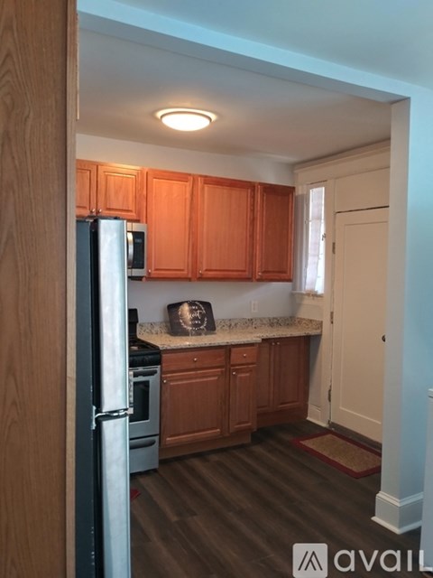 A kitchen with wooden cabinets and a refrigerator.