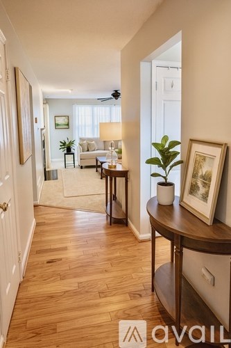 A hallway with wooden floors and white walls.