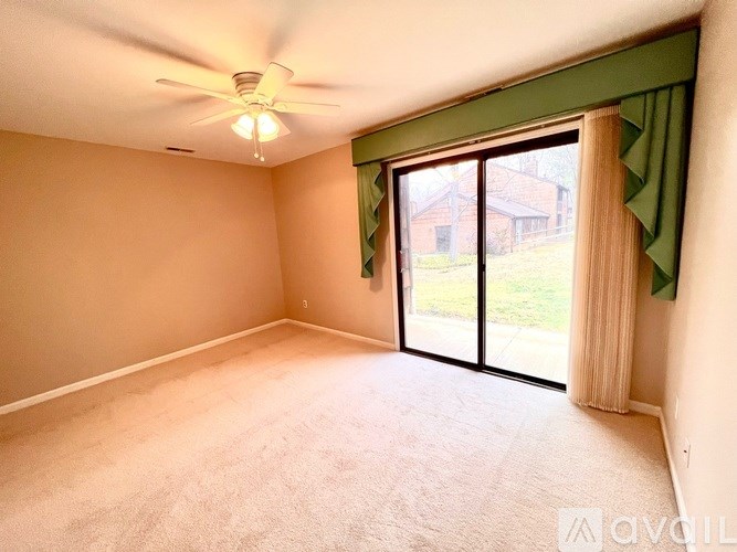 A room with a ceiling fan and a carpeted floor.