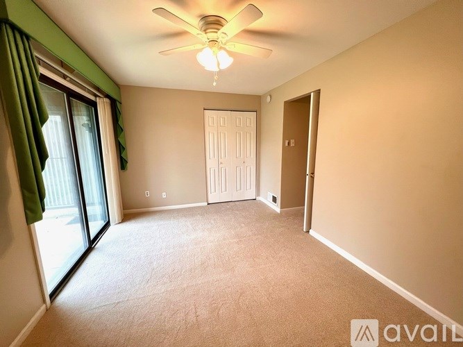A room with a ceiling fan and a door.