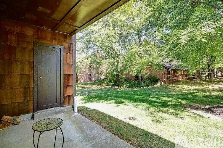 A patio with a table and a door leading to a backyard.