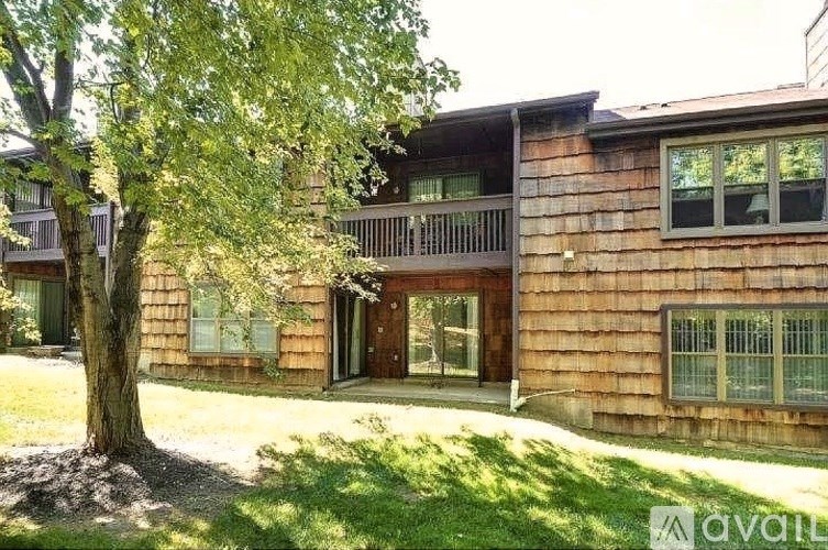 A wooden house with a tree in front of it.