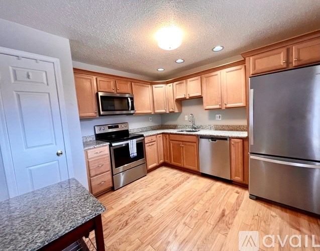 A kitchen with wooden cabinets and stainless steel appliances.