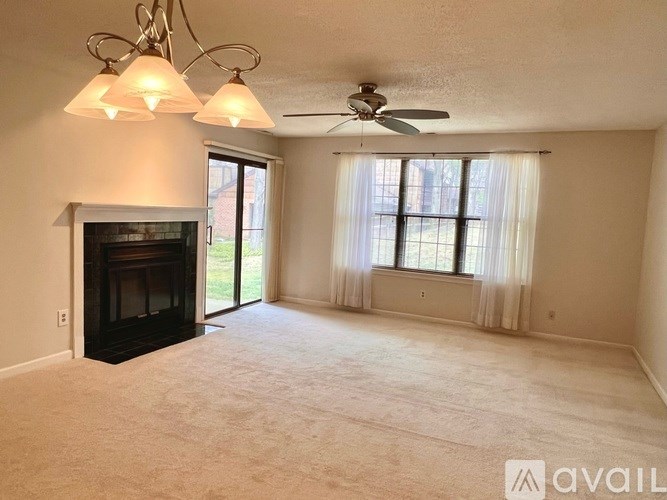 A living room with a fireplace and a ceiling fan.