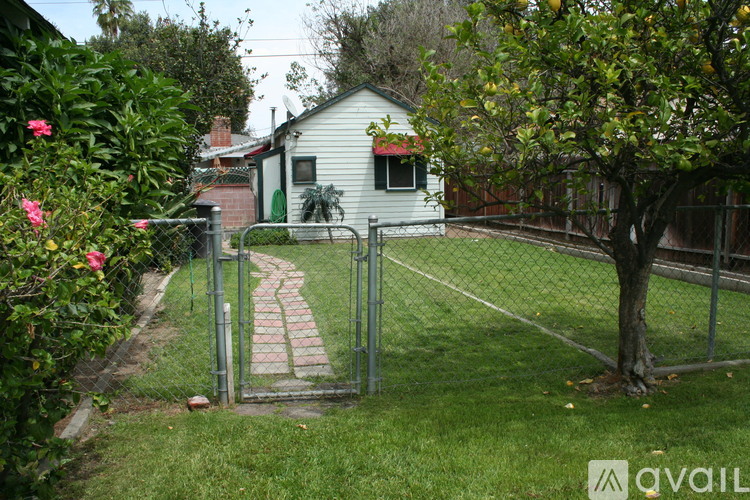 A small house with a green door and a fence surrounding the yard.