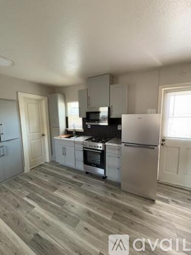A kitchen with a refrigerator, stove, and oven.