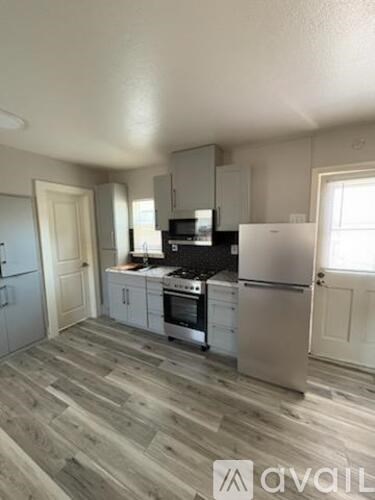 A kitchen with a refrigerator, stove, and oven.
