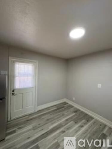 A room with wooden flooring and a white door.