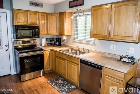 A kitchen with wooden cabinets and a stainless steel oven.