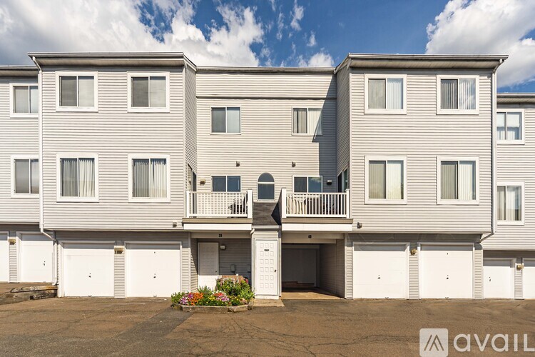 A row of identical townhouses with balconies and garages are available for rent.