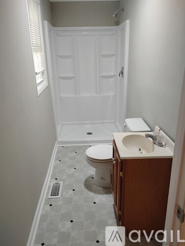 A bathroom with a toilet, sink, and shower.