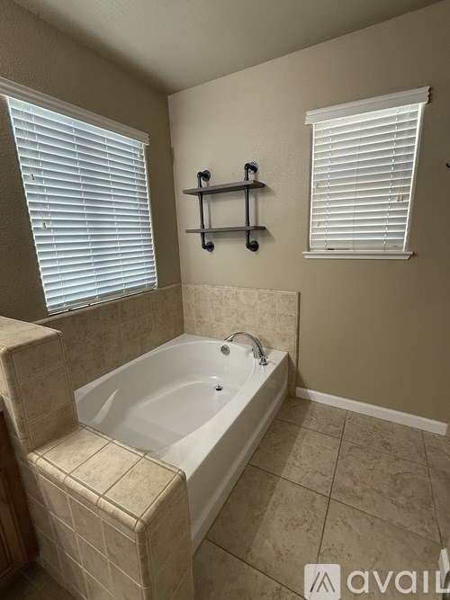 A bathroom with a white tub and a towel rack.