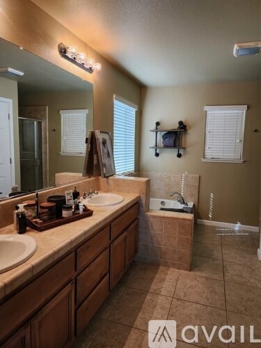 A bathroom with brown cabinets and a brown tiled floor.