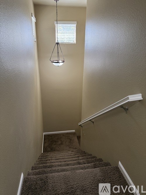 A staircase with a carpeted runner and a metal handrail.