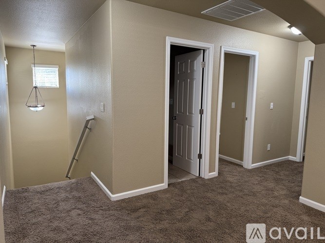 A room with a carpeted floor and a door in the middle.