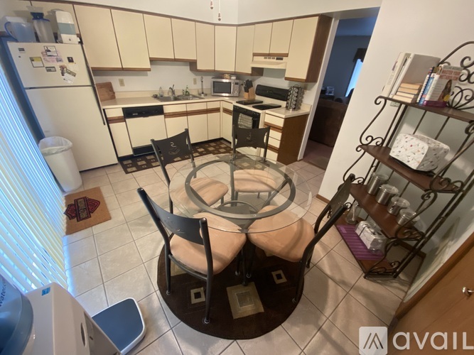 A kitchen with a table and chairs in the middle.
