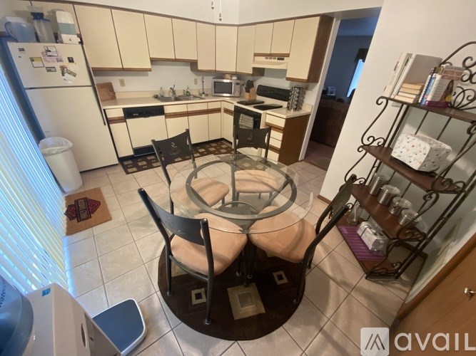 A kitchen with a table and chairs in the middle.