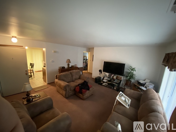 A living room with a couch, chair, and television.
