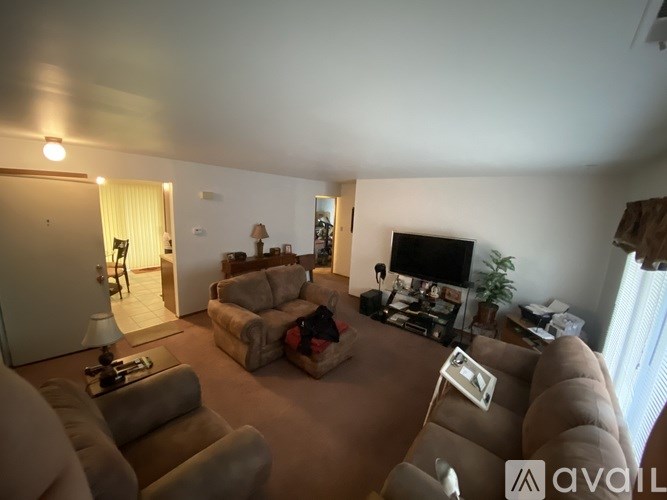 A living room with a couch, chair, and television.
