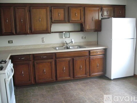 A kitchen with wooden cabinets and a white refrigerator.