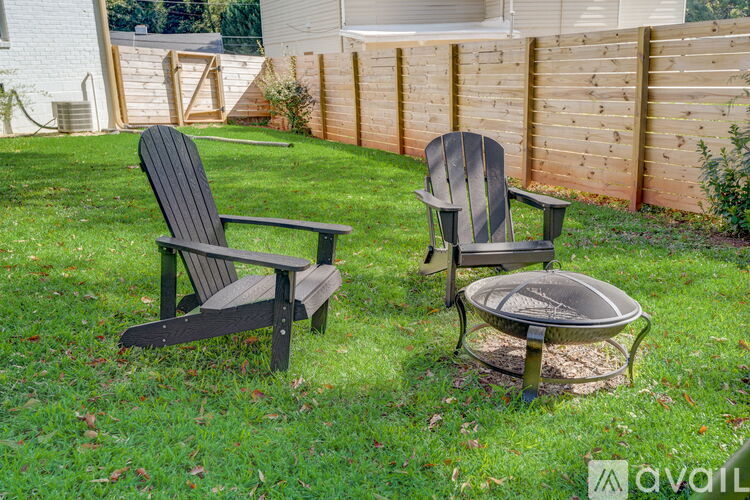 Two chairs and a table are placed on a grassy lawn.