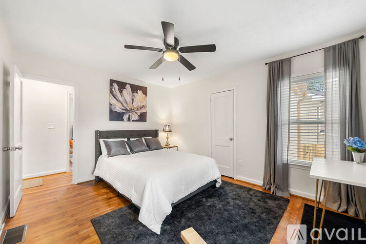 A bedroom with a large bed and a ceiling fan.