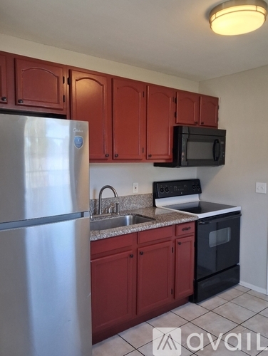 A kitchen with brown cabinets and a stainless steel refrigerator.