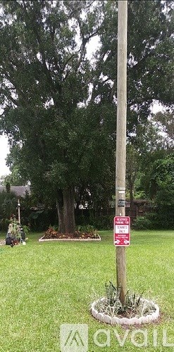 A sign on a pole in a grassy area.