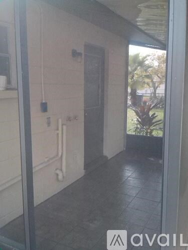 A hallway with a door and a wall-mounted phone.