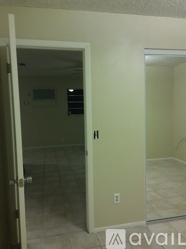 A room with a door and a wall socket.