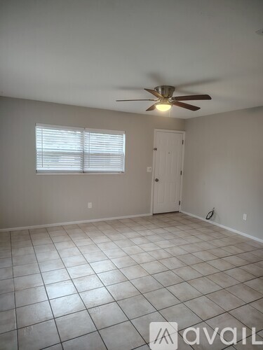 A room with a ceiling fan and a window with blinds.