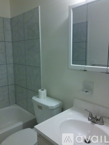 A white toilet sits next to a white sink in a bathroom.