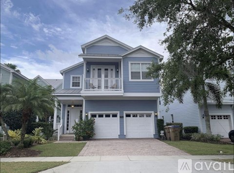 A two-story house with a garage and a balcony.