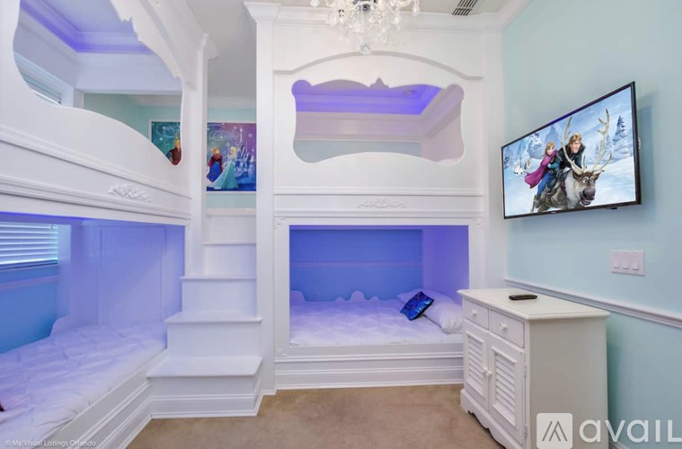 A room with a bunk bed and a TV mounted on the wall.