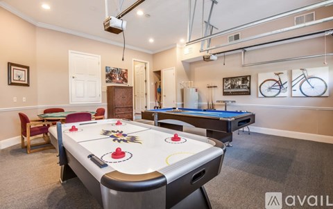 A room with a pool table and a bicycle on the wall.