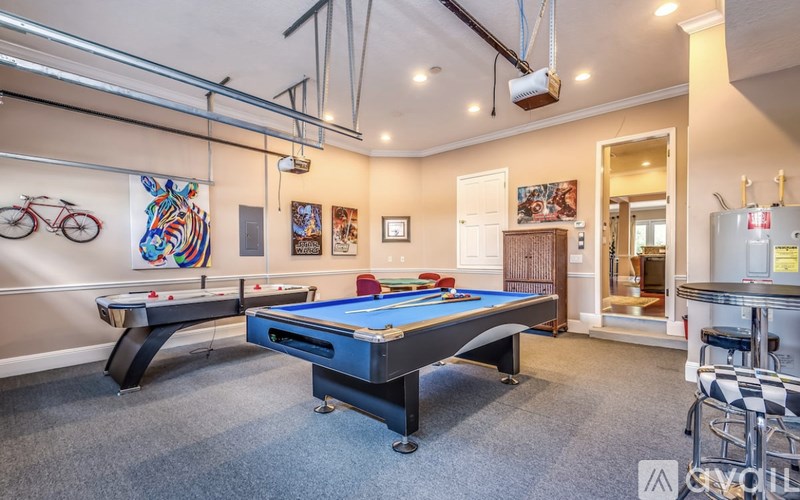 A room with a pool table and a bicycle on the wall.