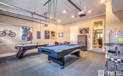 A room with a pool table and a bicycle on the wall.
