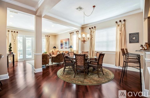 A living room with a wooden floor and a chandelier.